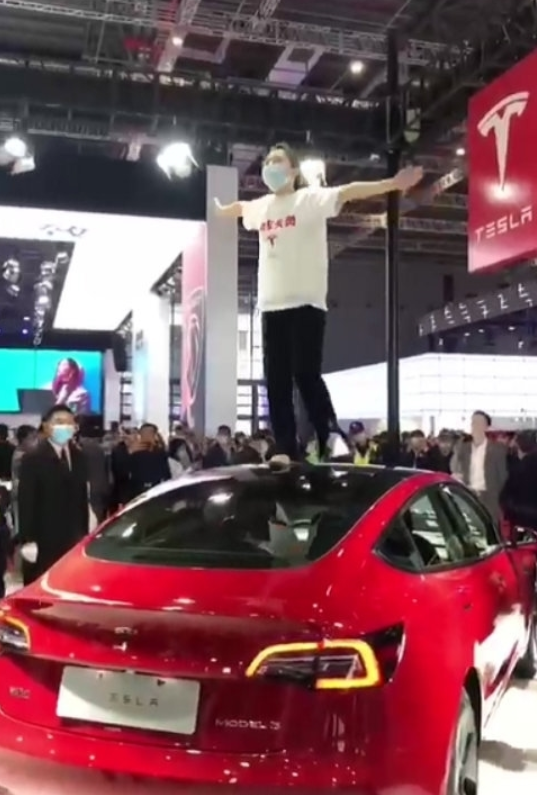 Woman Who Stood on Tesla at Auto Show Responds to $24,000 Fine: Appeal Upheld, But Doesn't Mean Brakes Work